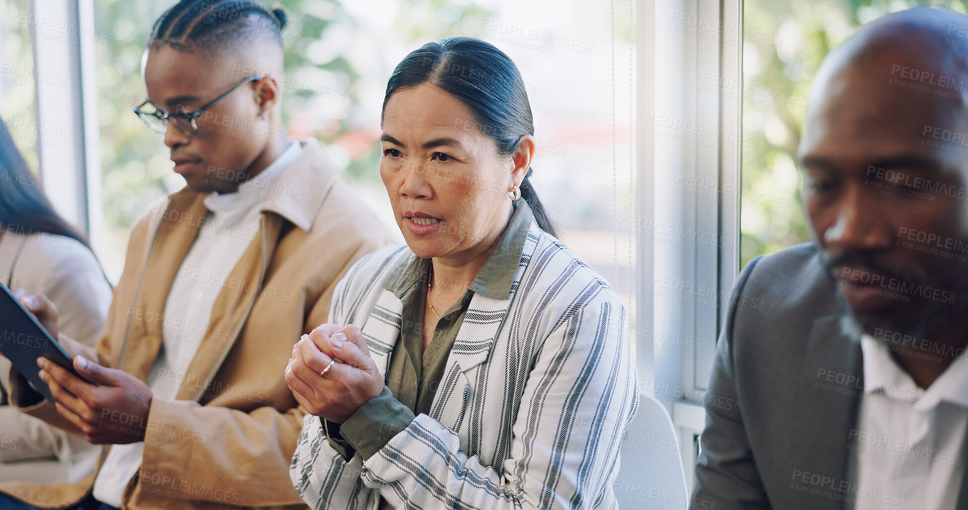 Buy stock photo Anxiety, interview and woman in waiting room with candidates at recruitment agency. Human resources, hiring and fear, men and women in lobby with hope, motivation and stress for new job opportunity.