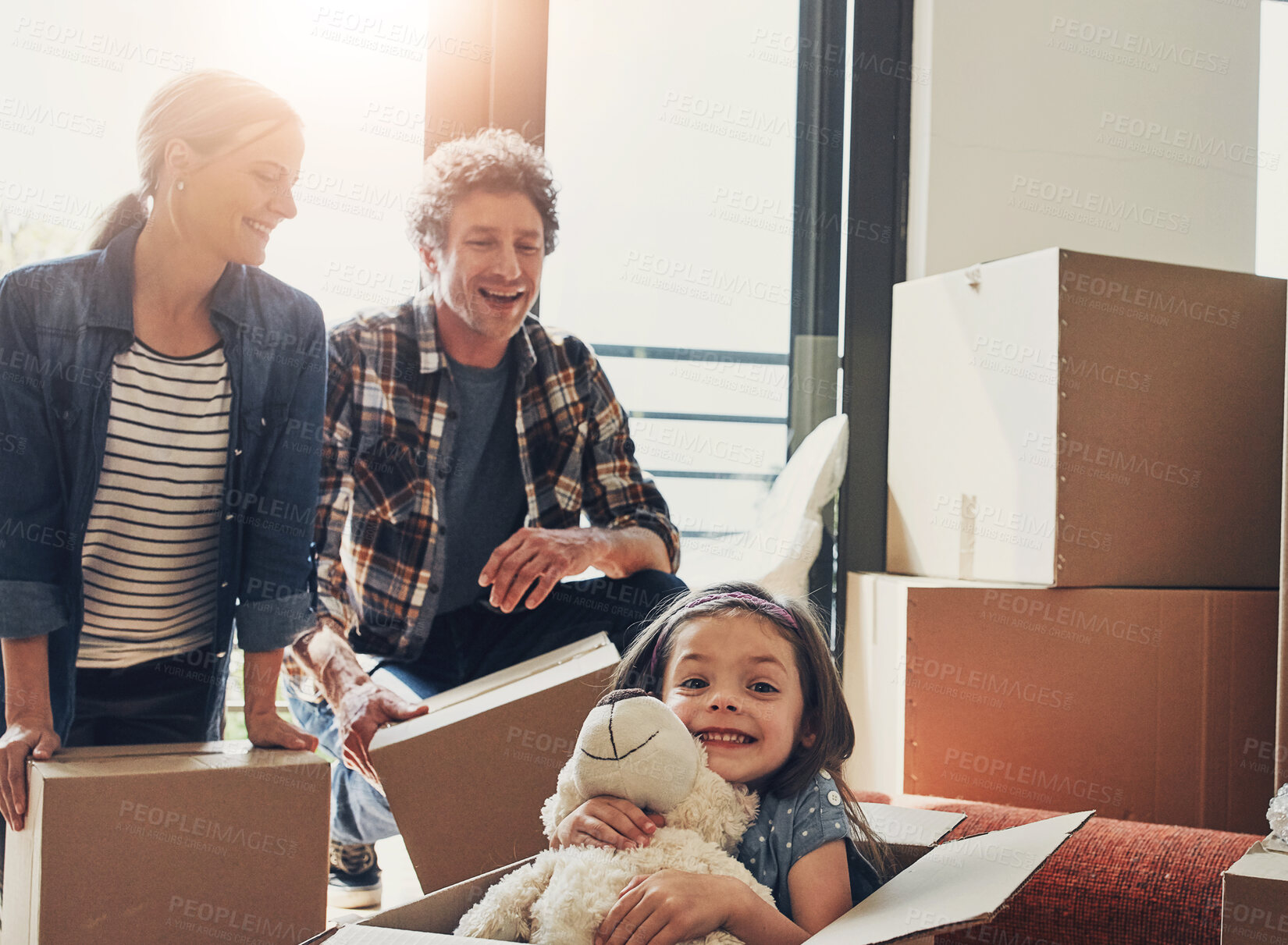 Buy stock photo Family, moving in to new home and girl in box with parents in living room of apartment for fun or relocation. Mortgage, property or unpacking with mother, father and daughter in house for rent