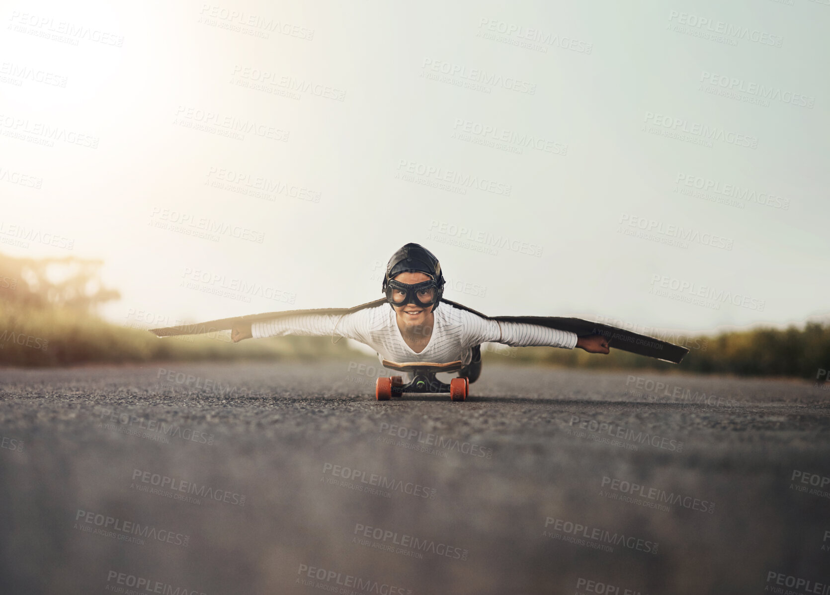 Buy stock photo Skateboard, wings and portrait of kid outdoor on road for airplane game, sport or mockup space. Pilot, freedom and happy boy in helmet flying on street for childhood dream, fantasy or playing pretend