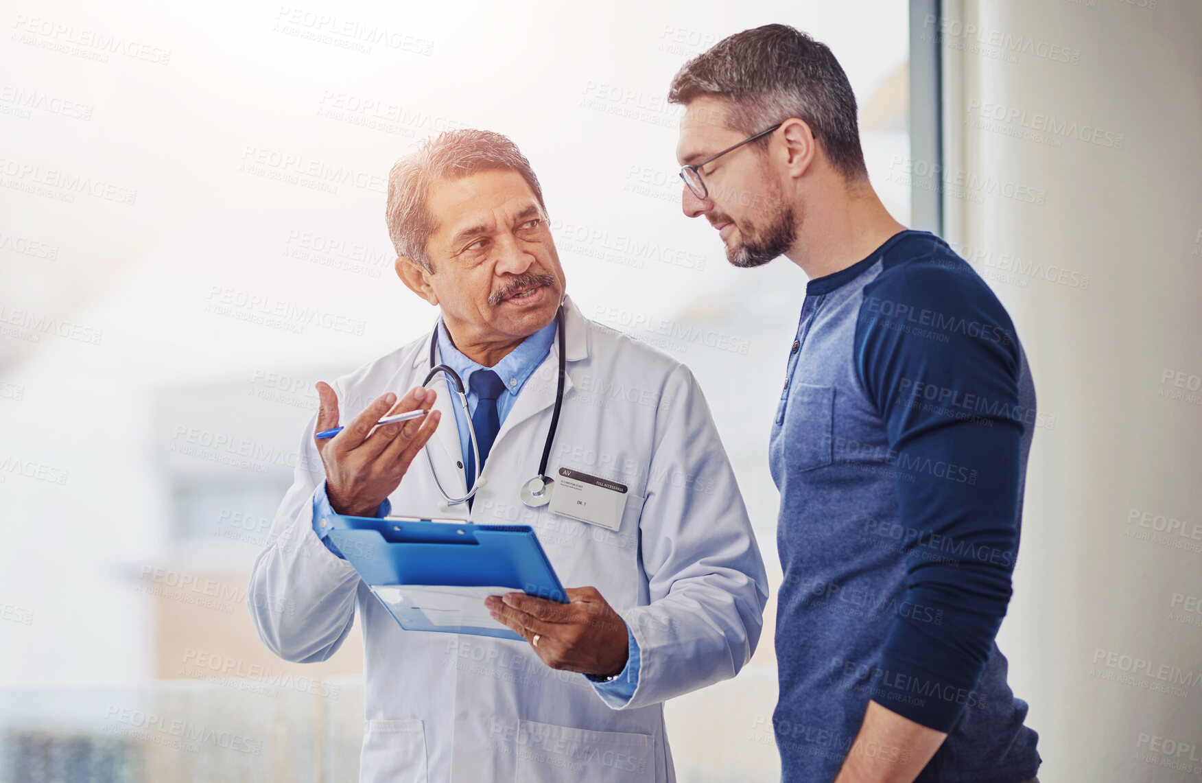 Buy stock photo Hospital, clipboard and man with doctor talking for medical results, health insurance and diagnosis. Healthcare, clinic and person and man with paperwork for consulting, assessment and appointment