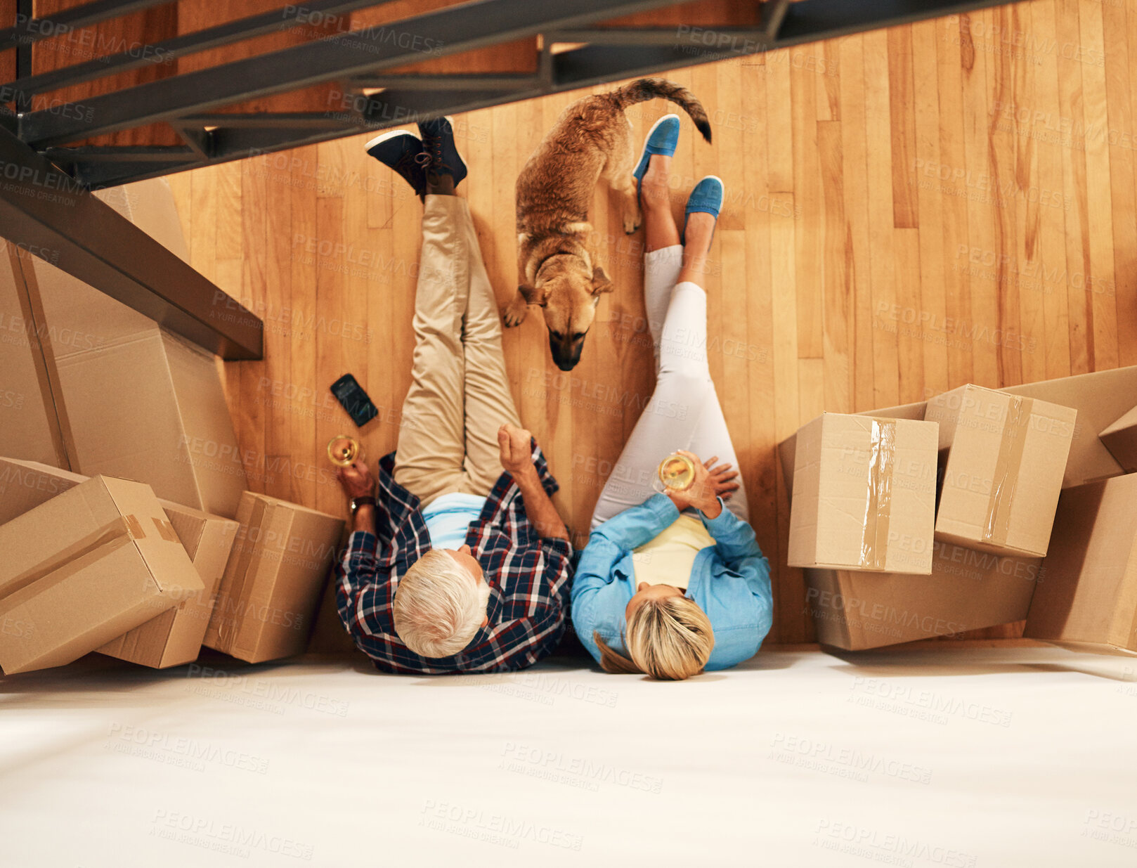 Buy stock photo High angle shot of a mature couple relaxing together with wine on moving day
