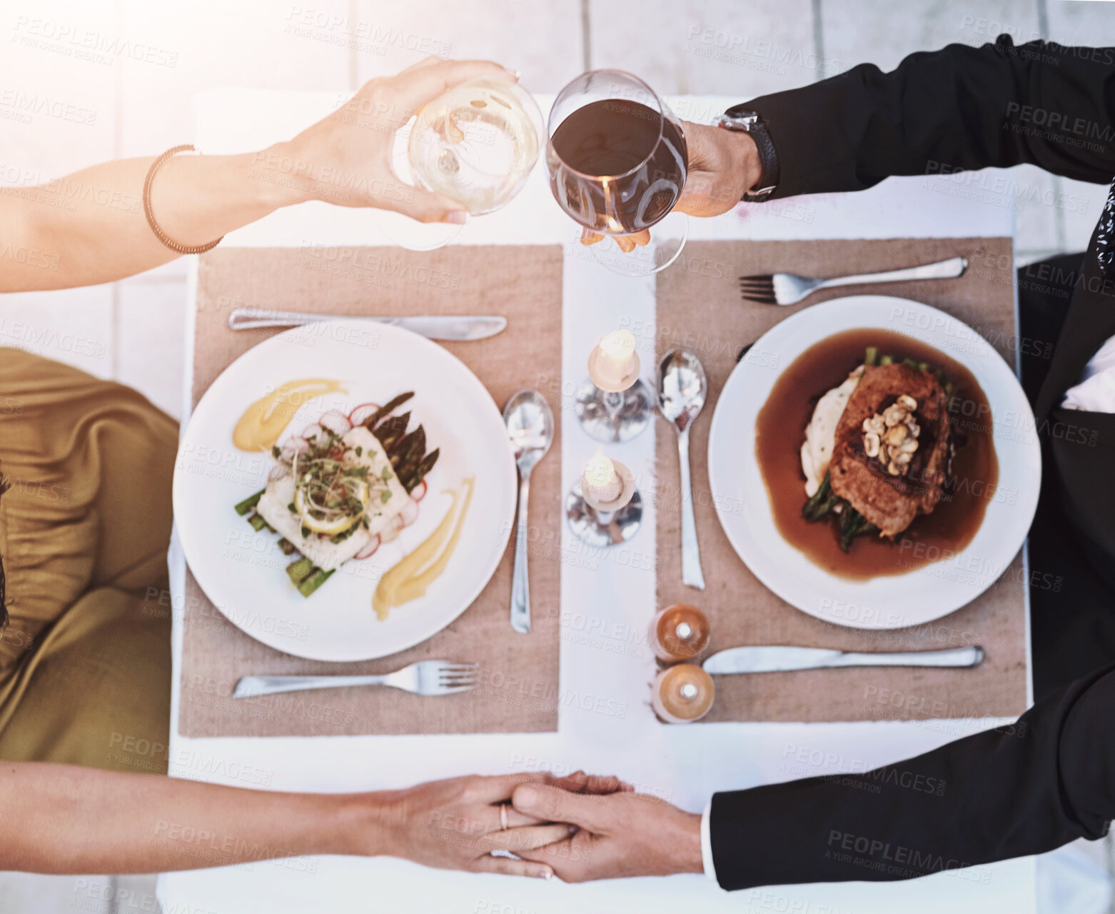 Buy stock photo Above, couple and toast with holding hands on dinner for unity, anniversary and love. Relationship, people and restaurant outside for commitment with support, care and trust with wine glasses