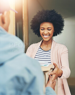 Buy stock photo Shot of a young woman receiving her delivery from the courier