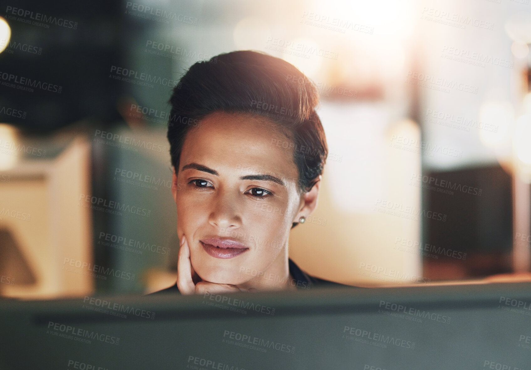 Buy stock photo Shot of a young businesswoman working late on a computer in an office