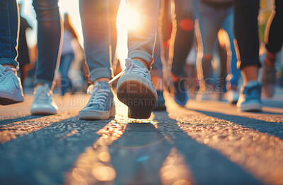 Closeup, shoes and group in street, walking and sunshine with lens flare, cooperation and protest. March, feet and people in city, tar road and summer with action for justice, forward and outdoor