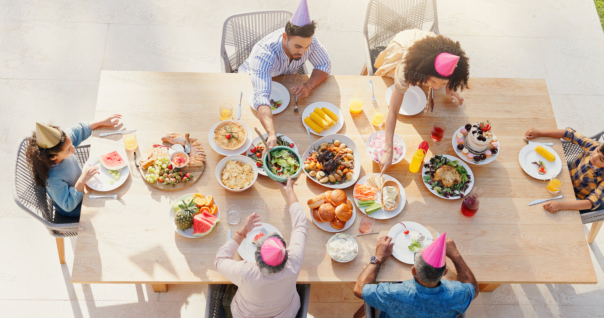 Buy stock photo Family, top view and birthday party in home with celebration, sharing and eating for bonding together for lunch. Generations, kids and summer with food in patio with nutrition and roast meat on table