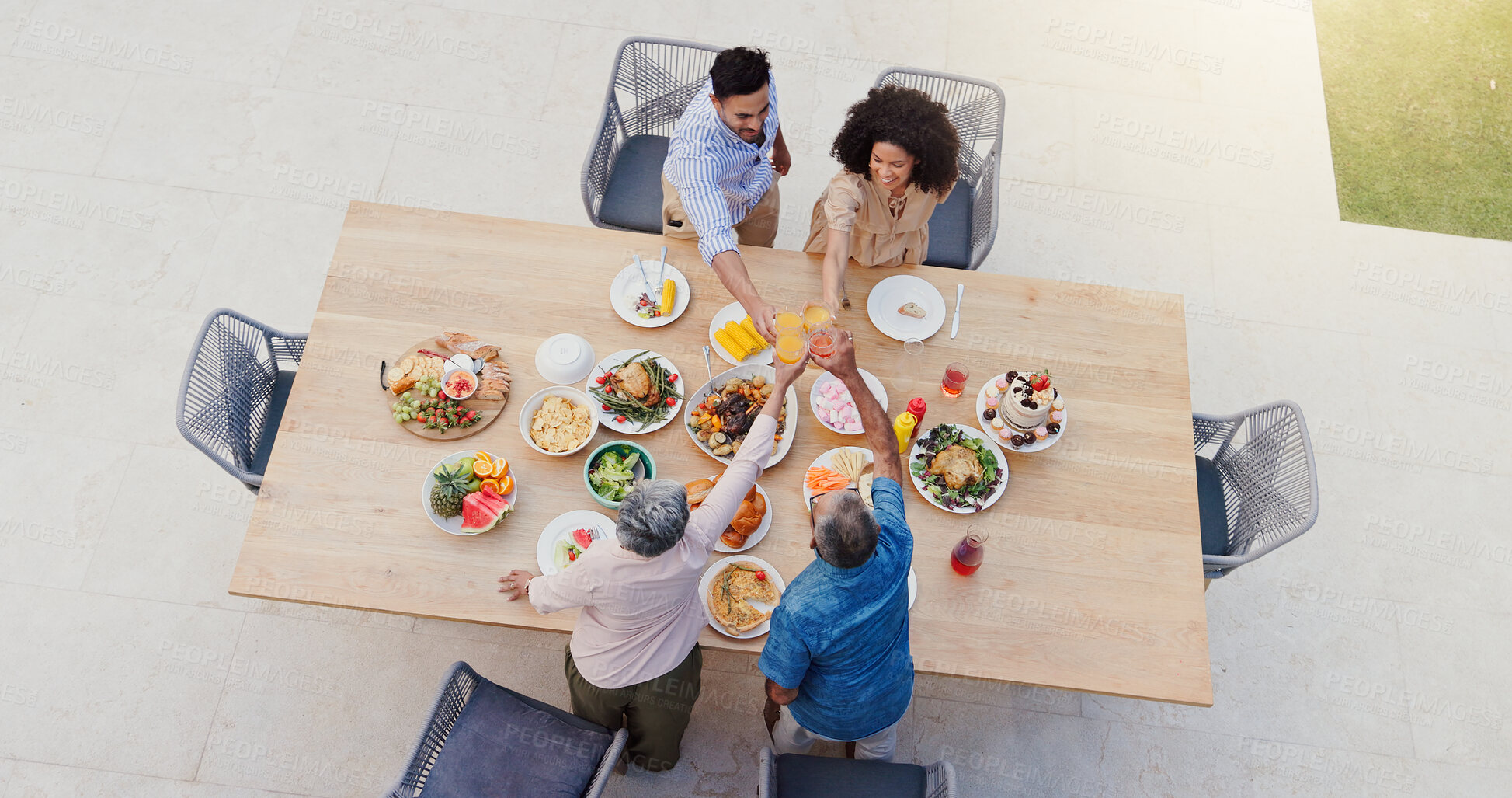 Buy stock photo Happy family, above or thanksgiving in garden with cheers, sharing and eating for bonding together by table. Generations, home or celebrate in backyard with nutrition, roast meat or toast with drinks