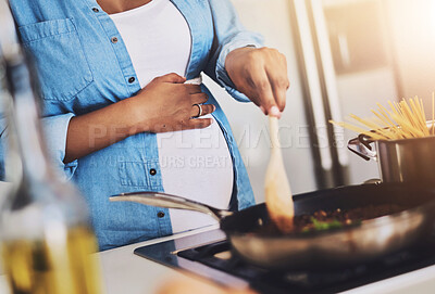 Buy stock photo Cropped shot of a pregnant woman preparing a meal on the stove at home