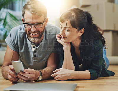 Buy stock photo Shot of a husband and wife using a mobile phone together on moving day
