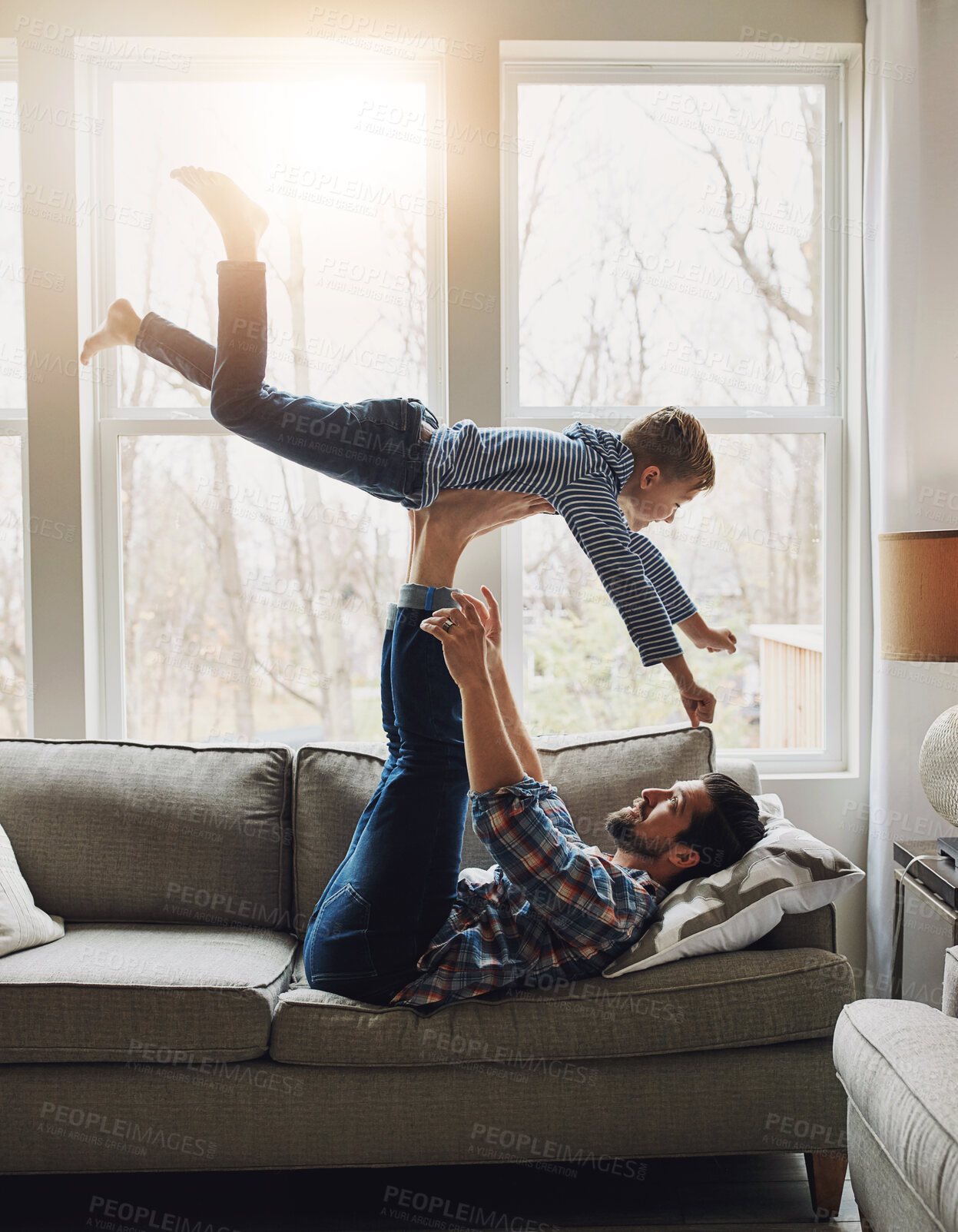 Buy stock photo Dad, son and support in house with fly for bonding, dream for superhero ability or childhood fantasy. Father, boy child and legs for airplane game or pilot on sofa, relax with flight in family home