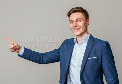 Happy man, pointing and business by studio background for marketing, product placement and notification for sale. Portrait, businessman and space for showing info with advertising and offer on mockup