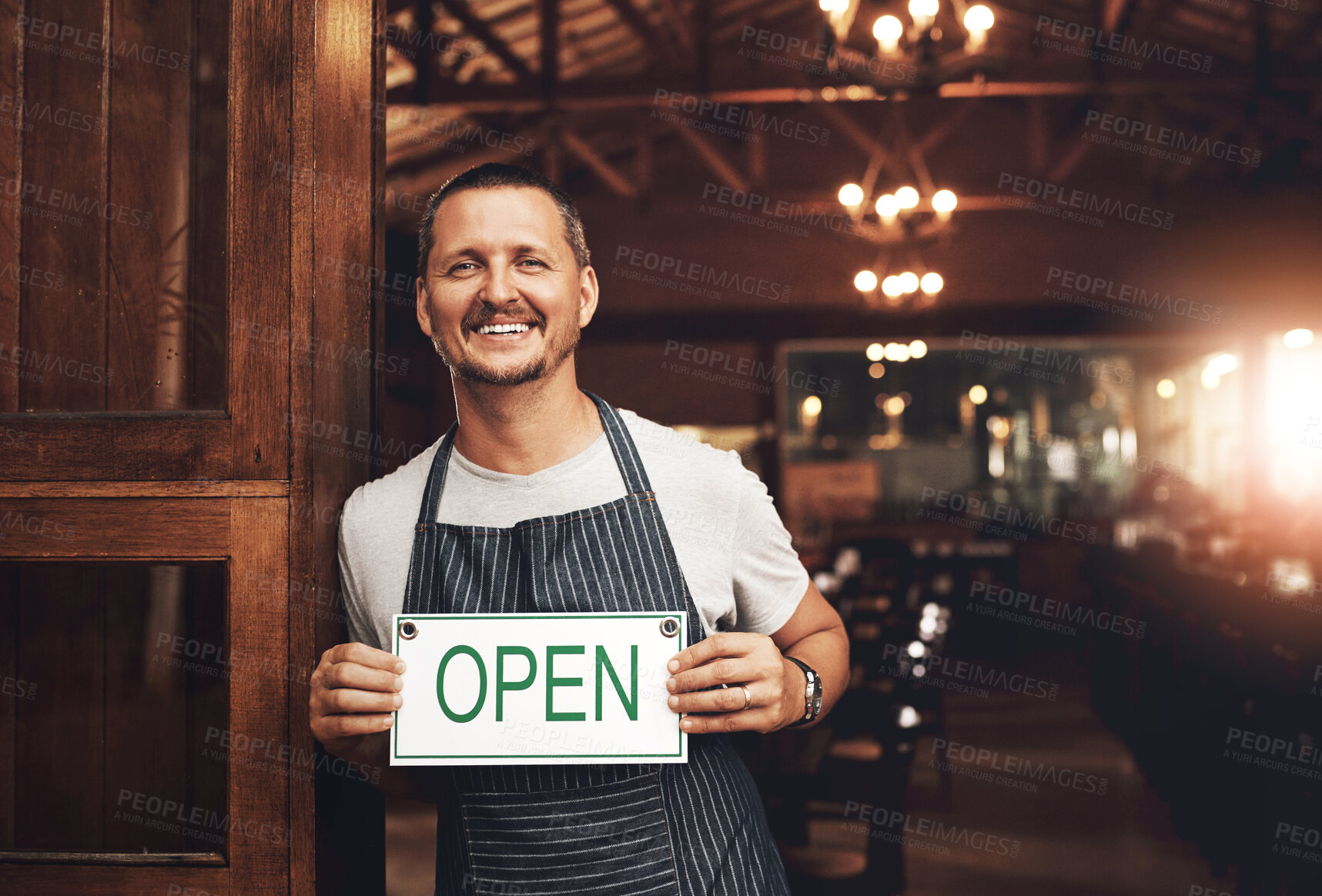 Buy stock photo Open sign, portrait and smile with man at brewery entrance for beer tasting, hospitality or service. Door, restaurant and small business owner with happy barista in apron for reopening of beerhouse