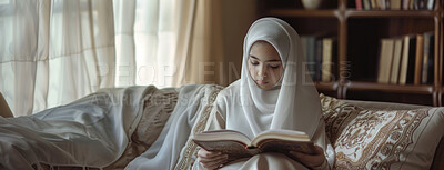 Buy stock photo Muslim, home and kid reading Quran on sofa for faith, religion or worship on EID in living room. Islam, girl and child study book for learning, education or spiritual knowledge on ramadan mubarak