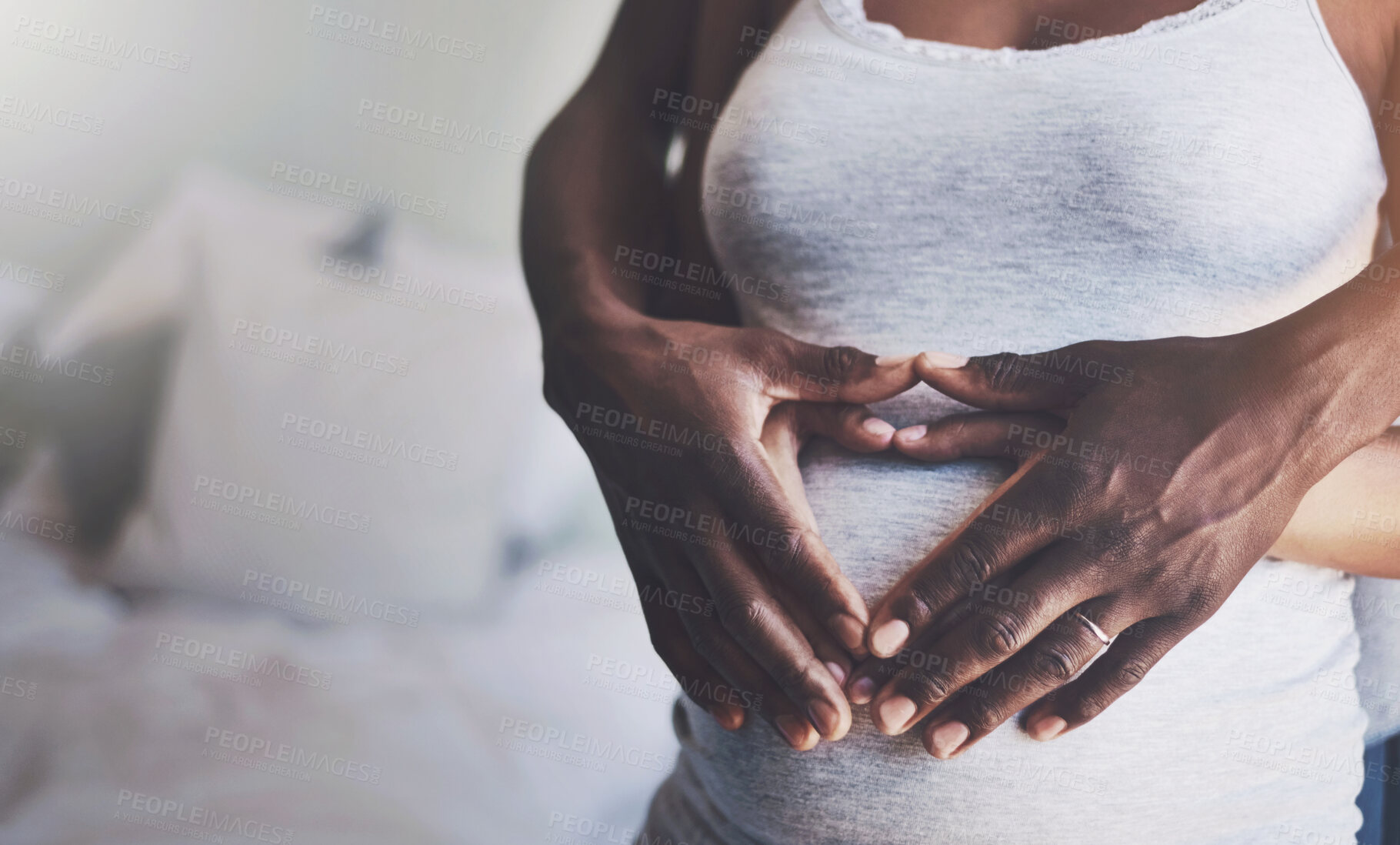 Buy stock photo Hands in heart, pregnancy and couple on stomach in bedroom for bonding, parenting and excited for baby. Family, maternity and man and pregnant woman embrace for love, affection and wellness in home