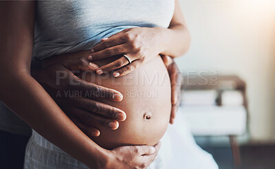 Buy stock photo Cropped shot of an unrecognizable man holding his pregnant wife's belly at home