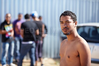 Buy stock photo Portrait of a young man standing with a group of friends in the background