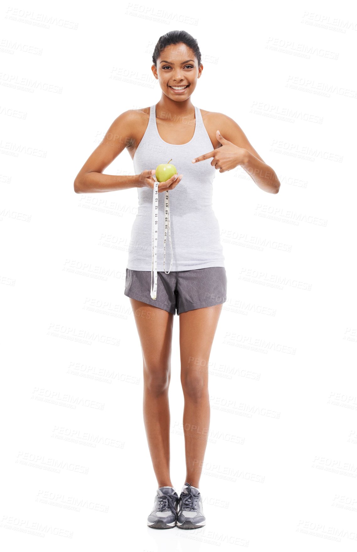 Buy stock photo Woman, lose weight and pointing to measuring tape and apple in white background or studio. Indian, model and happy with results of fitness, wellness and diet with healthy food, nutrition and fruit