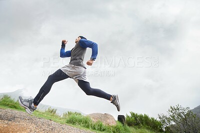 Buy stock photo Low angle, runner and man running in nature training, cardio exercise and endurance workout for wellness. Sports, fitness or healthy male athlete on fast jog on mountain outdoors with speed or action