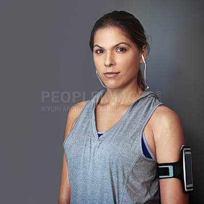 Buy stock photo Woman, phone and music in studio with armband for exercise audio, radio streaming or workout podcast. Athlete, mockup and listening to earphones for training motivation or wellness on grey background