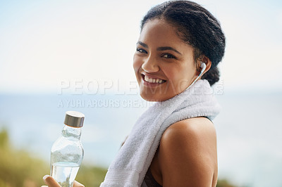 Buy stock photo Woman, portrait or water with headphones in nature for exercise, listening or streaming for workout. Female runner, natural smile or bottle for training by ocean, trail running in Brazil for wellness