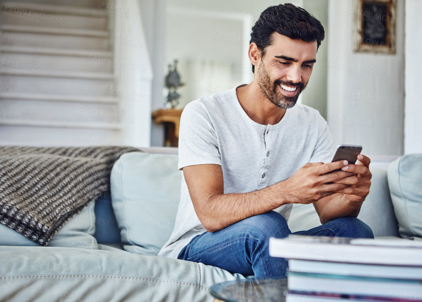 Buy stock photo Social media, mobile and happy man typing on sofa for texting, communication or online notification in living room. Contact, technology and person on couch for browsing, networking or web app in home