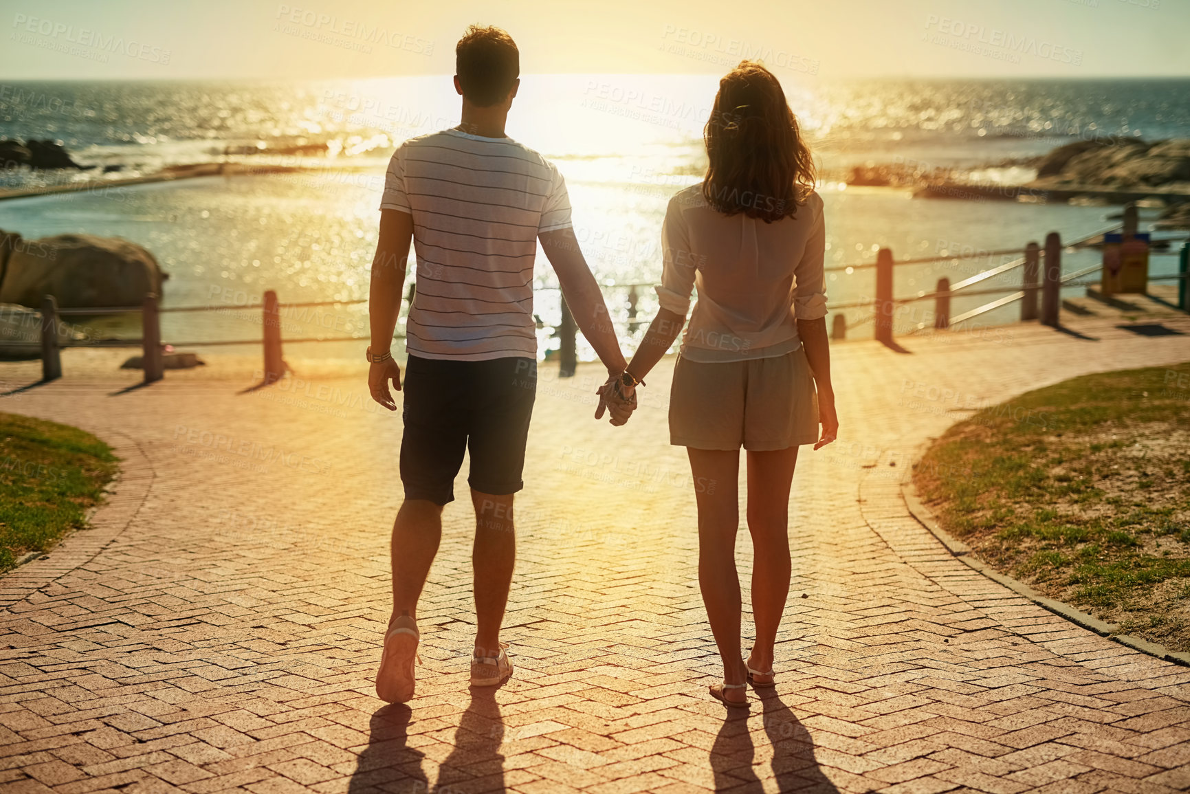 Buy stock photo Beach, holding hands and couple with love, summer and vacation for honeymoon, romance and getaway trip. Outdoor, seaside and man with woman, lens flare and adventure with support, travel and journey