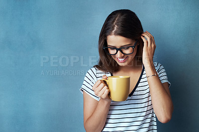Buy stock photo Woman, student and coffee in studio, drink and shy with glasses on blue background. Mockup, caffeine or energy or health for learner person, hands and matcha or green tea for morning latte and relax

