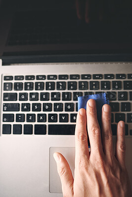 Buy stock photo Cropped shot of an unrecognisable man wiping a laptop with a cloth at home