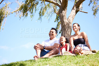 Buy stock photo Parents, girl and happy at picnic in park to relax by trees for holiday, bonding and love in nature. Father, mother and daughter on lawn, grass and outdoor for sunshine with care, smile and family