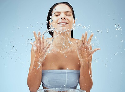 Buy stock photo Girl, studio and water splash on face for skincare , facial routine and daily treatment for self care with eyes closed. Woman, calm and liquid for dermatology, wellness and mock up on blue background