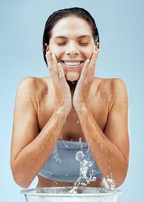 Buy stock photo Woman, studio and calm with water splash for skincare , facial routine and daily treatment for self care with eyes closed. Girl, cleansing and dermatology, wellness and isolated on blue background.