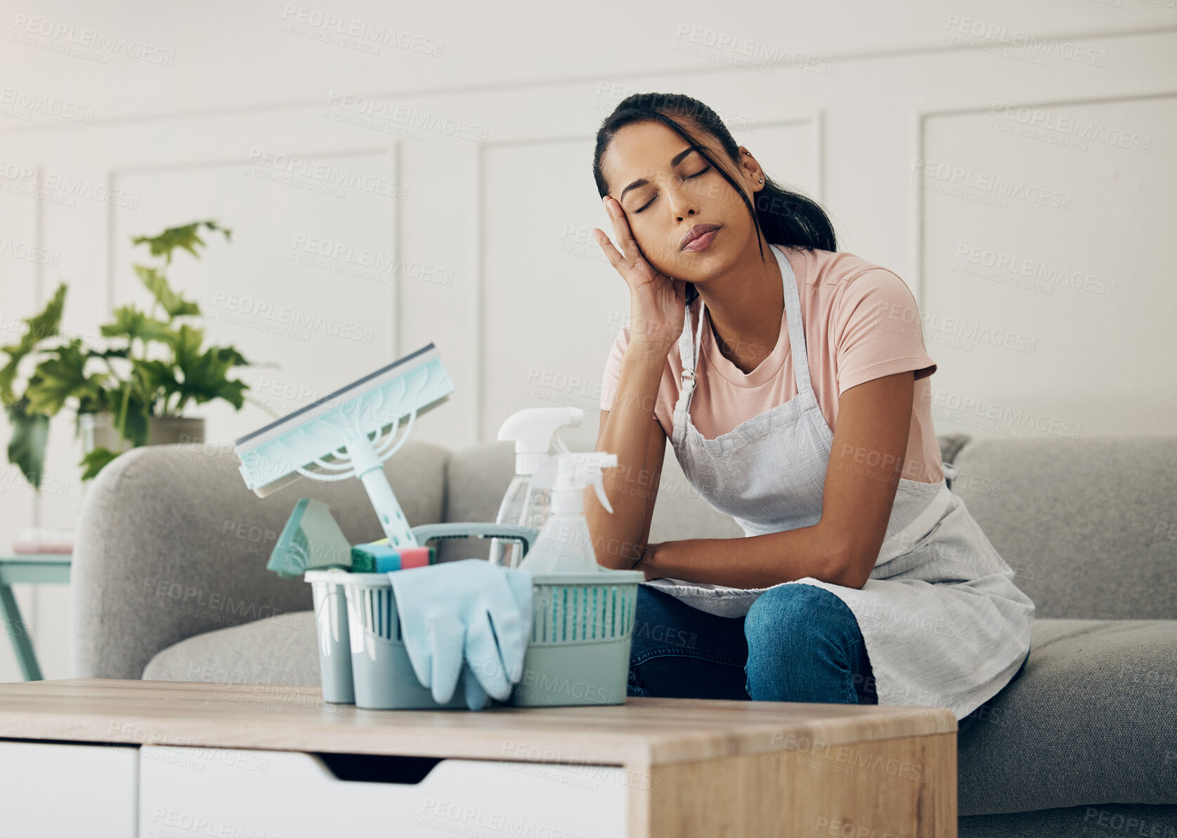 Buy stock photo Cleaning, tired and exhausted woman in a house to clean with supplies, detergents or tools. Young female or cleaner in a lounge with headache or stress in an apartment or room with fatigue or problem