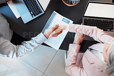 Buy stock photo High angle shot of two unrecognisable businesspeople shaking hands during a meeting in the office