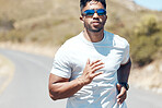 Portrait of a mixed race handsome young man wearing sunglasses running alone outside during the day. Hispanic male exercising outside during a run in the road outdoors