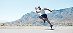 A fit handsome mixed race handsome young man wearing sunglasses running alone outside during the day. Indian male exercising outside during a run in the road outdoors