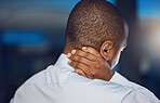 Above rearview young african man holding his neck in pain. African american business man suffering from the stress and pressure of deadlines which is causing anxiety, tension and stiff muscles