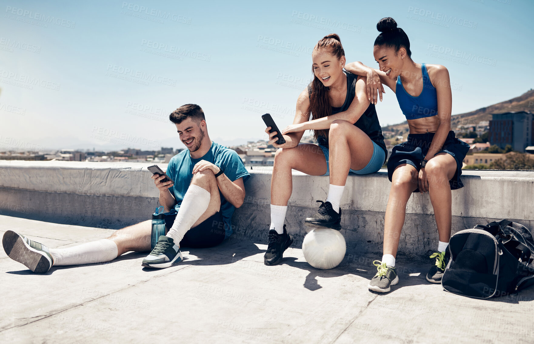 Buy stock photo Sport friends, phone and relax in city after exercise and morning cardio, physical exercise and soccer training. Fitness, soccer player and town hangout with diverse people talking after workout