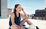 City sports, fitness and woman sitting to relax with water, ball and earbuds. Workout, rest and happy rooftop exercise, fun with urban soccer training and music streaming app in headphones in summer.