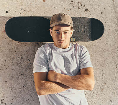 Buy stock photo Skateboard, fashion or man with arms crossed in city skate park for stunt training, hobby exercise or freestyle skating in top view. Portrait, skater or skateboarder lying on concrete ground or floor