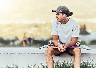 Buy stock photo Young man, skateboard and relax outdoor, thinking or chill being casual, trendy and earphones. Mockup, male skater or idea for break, calm or cool look being edgy, content or hipster on weekend style