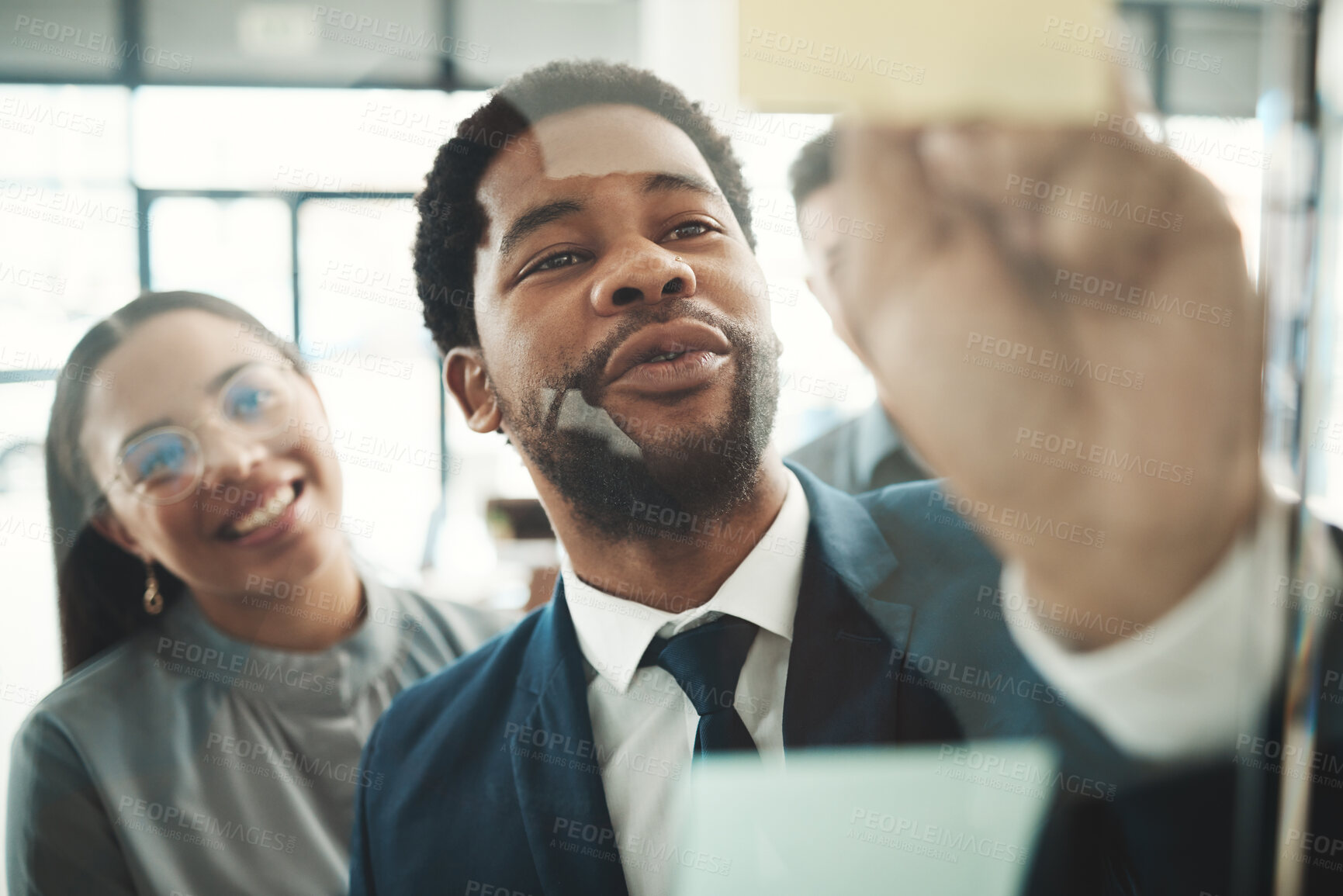 Buy stock photo Businessman, writing and planning schedule, strategy or brainstorming on glass wall at office. Group of employee workers in team project plan, tasks and write on sticky note together