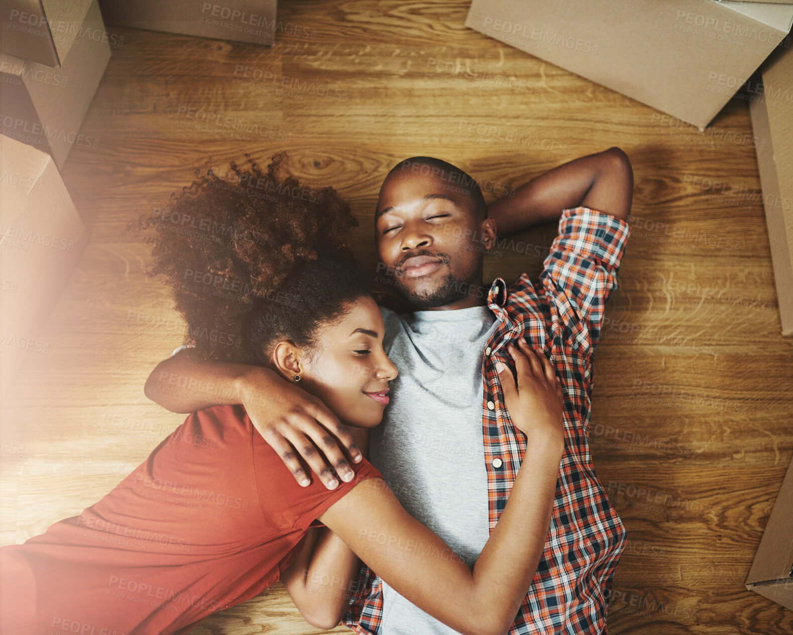 Buy stock photo Sleep, moving and black couple on floor in new home with boxes, tired hug and mortgage with high angle. Relax, man and woman in house with romantic embrace with love property investment and fatigue