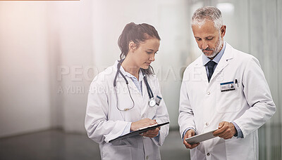 Buy stock photo Doctors, man and woman in corridor or tablet, clipboard and reading for results, medical research or notes. People, mentorship and learning with checklist, touchscreen and teamwork on app in clinic