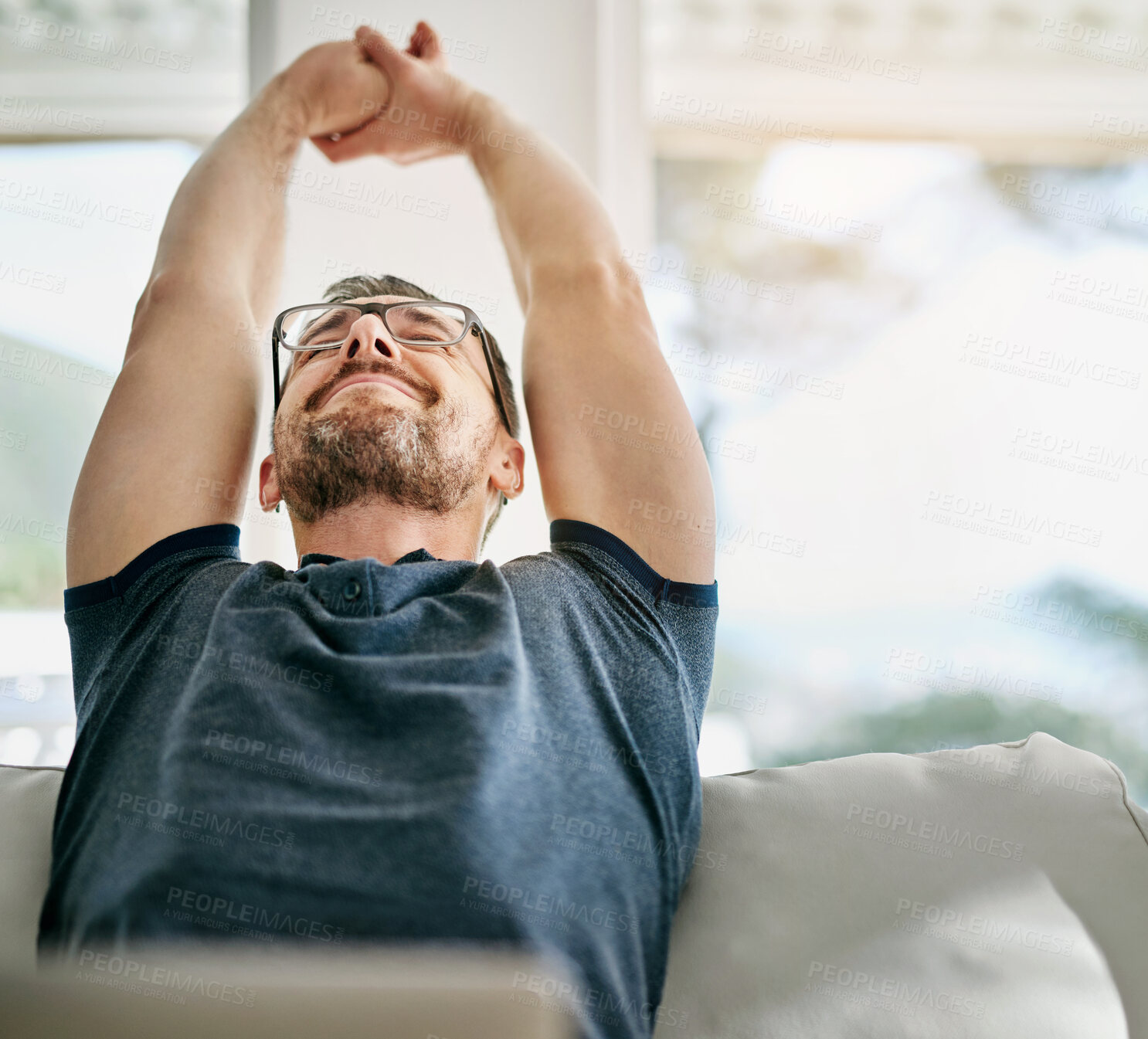 Buy stock photo Man, stretching and relax on sofa in house for vacation, wellness and peace on weekend with smile. Manager, tech and couch in home living room for holiday, freedom and calm mind on mental health day