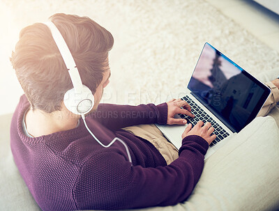 Buy stock photo Man, laptop and music on sofa in home with top view for audio streaming, subscription service and online gaming. Person, headphones and typing on tech app for sound entertainment, radio and playlist