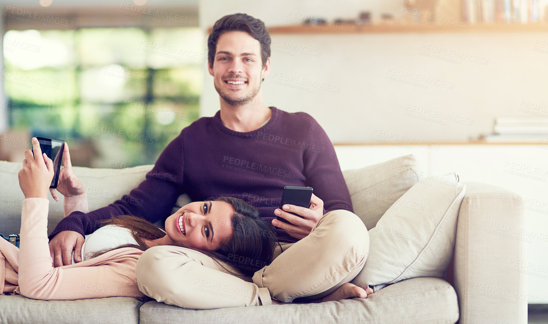 Buy stock photo Couple, portrait and relax on sofa with phone, tablet and connectivity for app in home living room. Man, woman and technology with bonding, care and morning on vacation with smile on couch in house