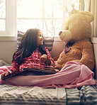 Bed, girl and smile at teddy bear with book in home for storytelling, child development or fun. Happy, literature and kid with stuffed animal in house for fairytale, education or enjoyment in morning