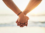Couple, closeup and holding hands at beach for support or love, romance in relationship on holiday. People, zoom and palms together by ocean with trust on vacation, dating with travel in nature