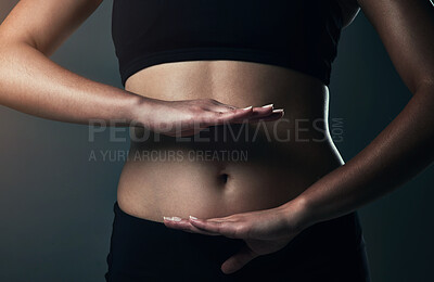 Buy stock photo Gut health, stomach and hands of person, healthy and diet for body, fitness and workout in studio. Black background, model and sportswear for healthcare, training and results of exercise and wellness