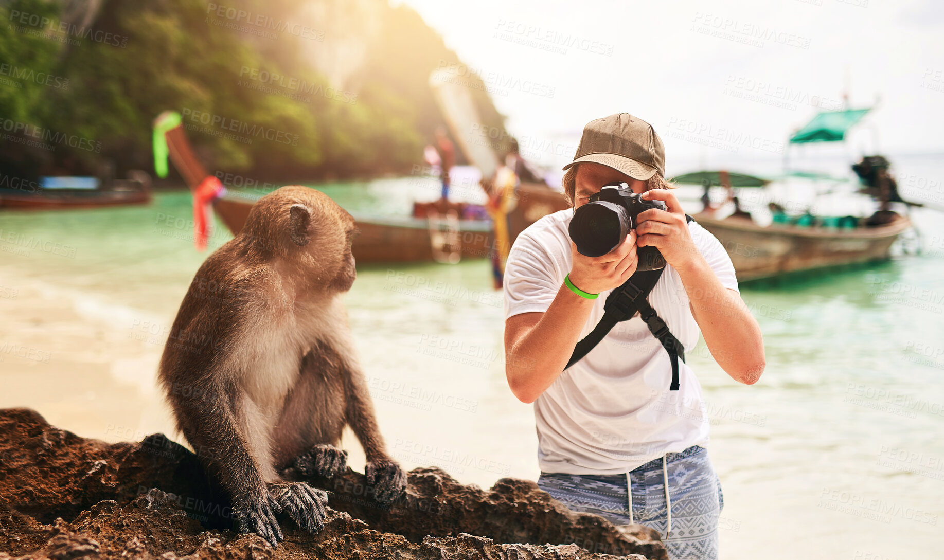 Buy stock photo Man, camera and monkey with holiday, beach and tropical island with getaway trip, Bali and tourism. Person, photographer and tourist with equipment, seaside and memory with wild animal and sunshine